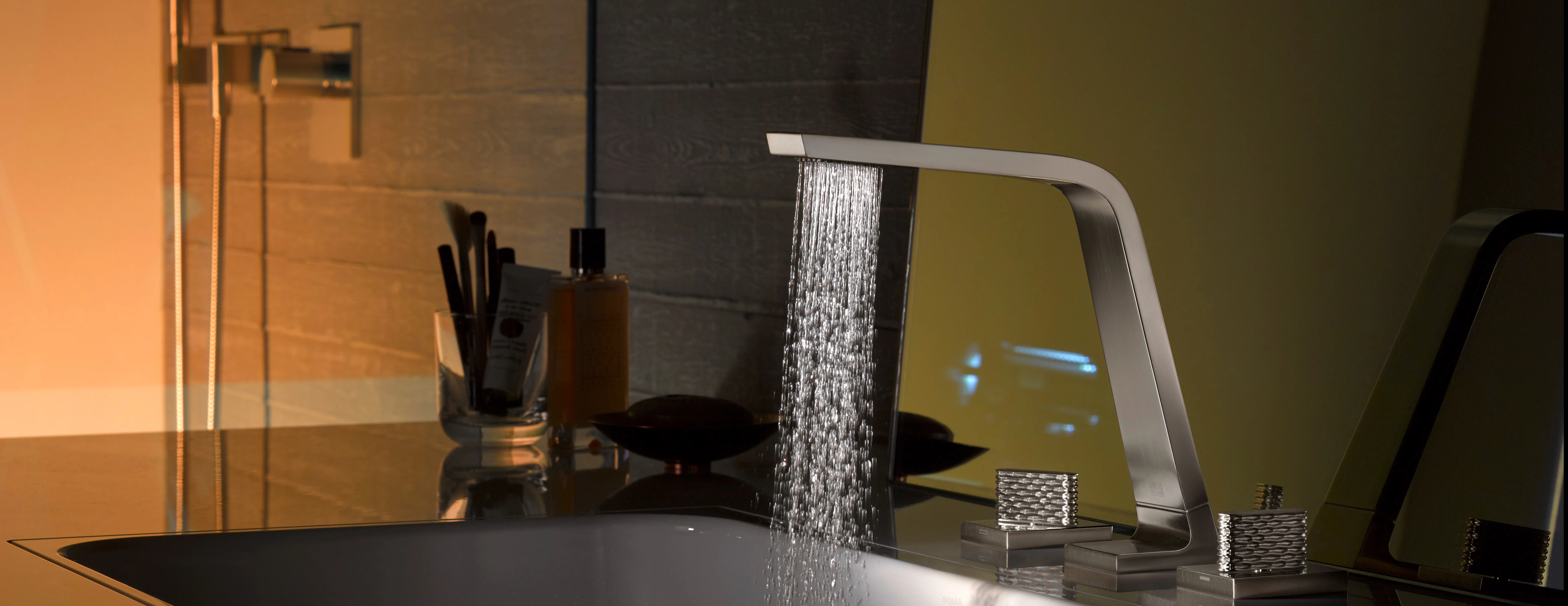 Eine moderne, stilvolle Armatur mit kantigem Design lässt einen gleichmäßigen Wasserstrahl in ein rechteckiges Waschbecken fließen. 