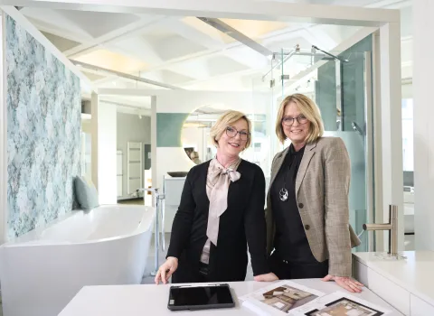 ZweiBadplanerinnen in der Bad-Ausstellung eines SHK-Handwerksbetriebes.
