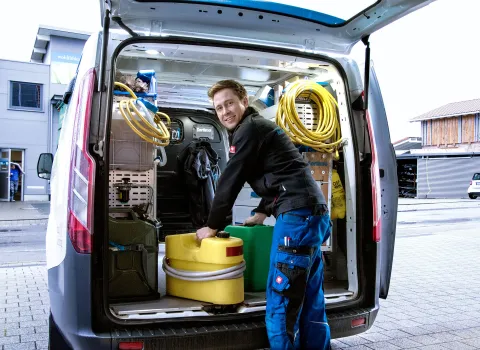 Kundendiensttechniker (SHK) vor Service-Fahrzeug.
