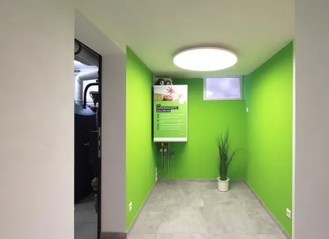 Ein kleiner Raum mit hellgrünen Wänden, in dem eine Infotafel zur Energieunabhängigkeit hängt.