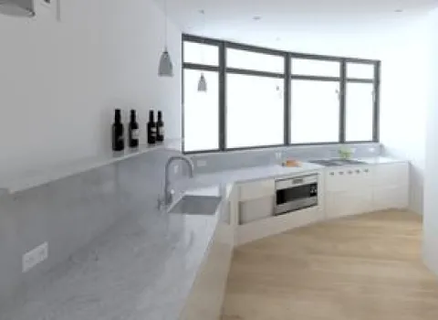 3D-Visualisierung einer modernen Küche mit großzügiger Fensterfront, die viel Tageslicht hereinlässt. Die Arbeitsflächen aus hellem Marmor und die weißen Einbauschränke verleihen der Küche ein elegantes, offenes Ambiente. Dezente Hängeleuchten und die geschwungene Form der Arbeitsbereiche unterstreichen das zeitgemäße Design.
