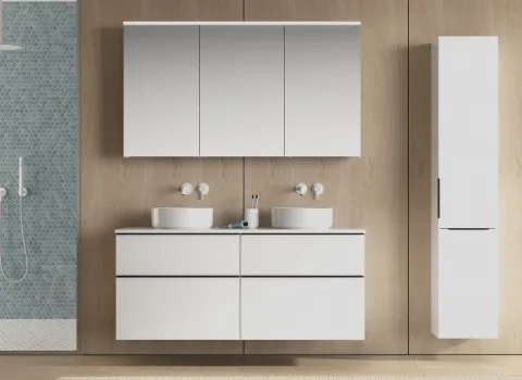 Der Doppelwaschtisch Burgbad Eqio zeigt zwei gleichmäßige Waschbecken mit dazugehörigen weißen Armaturen, eingebettet in eine stilvolle Badmöbel-Kombination.