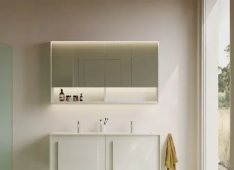 Ein minimalistisches Bad wird durch einen großflächigen LED-Spiegelschrank dominiert, der gleichmäßig hinterleuchtet ist und eine elegante Atmosphäre schafft.