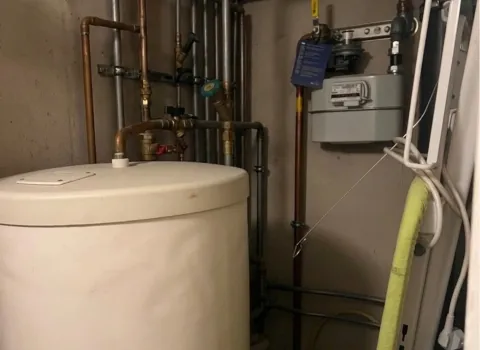 Kompakter Heizungskeller mit Boiler und Gaszuleitung mit strukturierter Rohrführung.