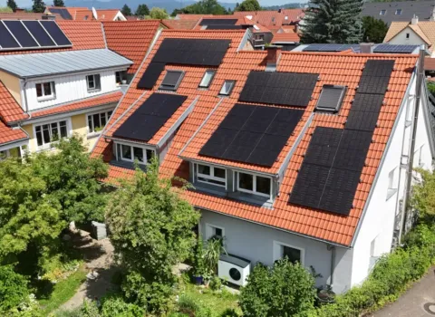 Mehrfamilienhaus mit Solardach und Wärmepumpe.