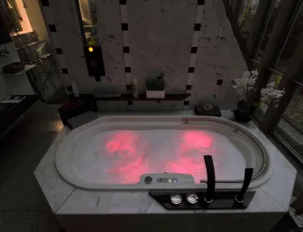 Ein luxuriöser Whirlpool in einem modernen Badezimmer, dessen Wasser in roter LED-Beleuchtung schimmert. 