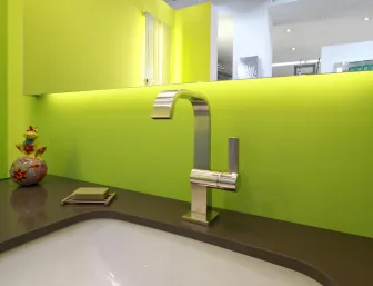 Ein moderner Waschtisch mit einem eleganten, verchromten Wasserhahn, der auf einer dunkelgrauen Arbeitsplatte montiert ist. 