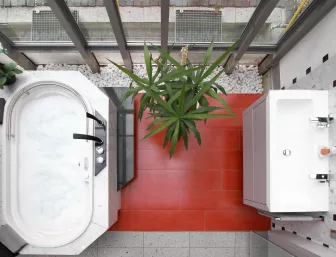 Eine Draufsicht auf ein modernes Badezimmer mit einem ovalen Whirlpool, der in eine Marmoroberfläche eingebettet ist. 