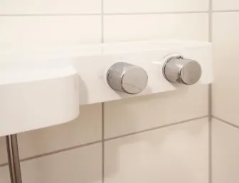 Detailaufnahme einer modernen Badarmatur mit klaren, minimalistischen Bedienelementen.