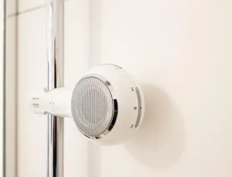 Nahaufnahme eines modernen, in die Duschstange integrierten Badradios für ein entspanntes Duscherlebnis.
