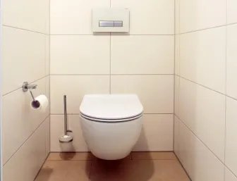 Modernes, wandhängendes WC mit schlichtem Design und hellen Wandfliesen für ein stilvolles und hygienisches Badezimmer.