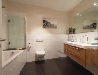 Ein modernes Badezimmer mit einer Kombination aus Holz- und Weißtönen, ausgestattet mit einer Badewanne, einer Glasduschabtrennung und einer wandhängenden Toilette.