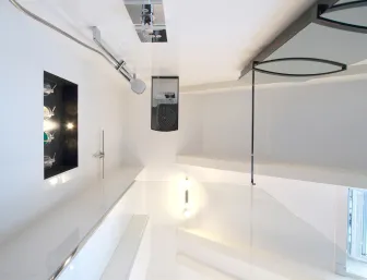 Ein eingebautes Wandregal mit dunklem Hintergrund, das von einer kleinen Lampe oben beleuchtet wird. 