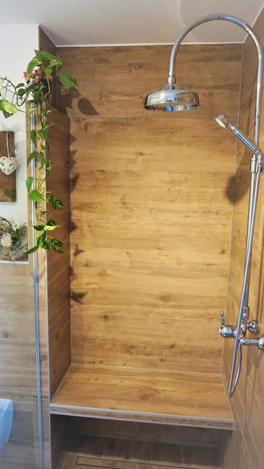 Eine moderne Walk-In-Dusche mit Wänden und Boden in Holzoptik, die ein warmes und natürliches Ambiente schaffen.
